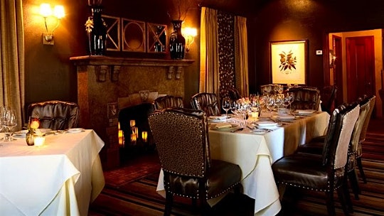 The dining room at the Hobbit, with leopard-print chairs and a stone fireplace